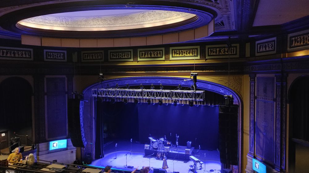 photo inside the old theater. At the type is a circle cutout in the ceiling with decorations on the rim