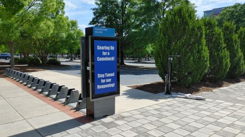 image of empty bike parking next to a massive block sized parking lot