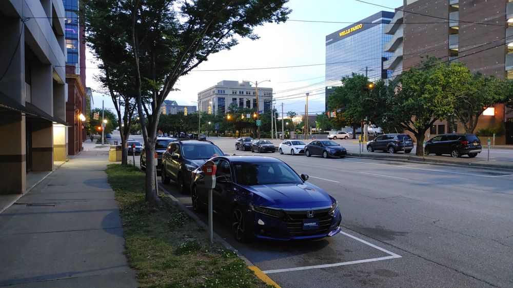 photo of avenue with parking spots both on the sides and in the middle near the mediam